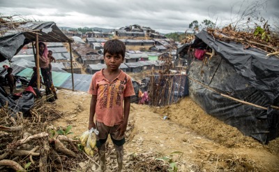 Muk Kashim, aged 8, holds bags of food aid in Cox's Bazar, Bangladesh