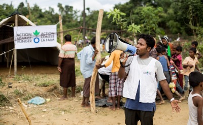 An Action Against Hunger aid worker organizes an emergency food distribution for Rohingya refugees in Cox's Bazar, Bangladesh