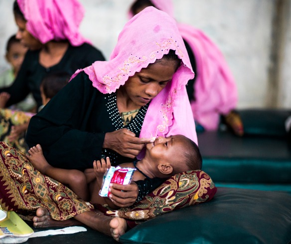 A mother gives her baby Plumpy'Nut to treat malnutrition at an Action Against Hunger nutrition center.