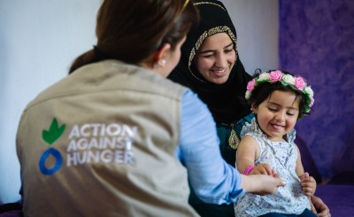 A mother and child talk with an Action Against Hunger psychosocial worker.