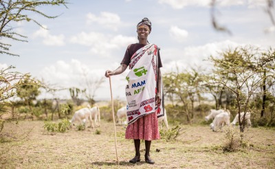 A member of one of Action Against Hunger's mother-to-mother support groups stands in front of her livestock.