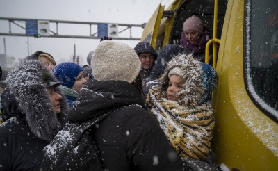Ukrainian refugees face winter weather as they board a bus and cross the border into Moldova.