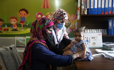 Dr. Zarina Lashari, a nutrition assistant, consults with a mother and child at an outpatient treatment center in Sindh, Pakistan.