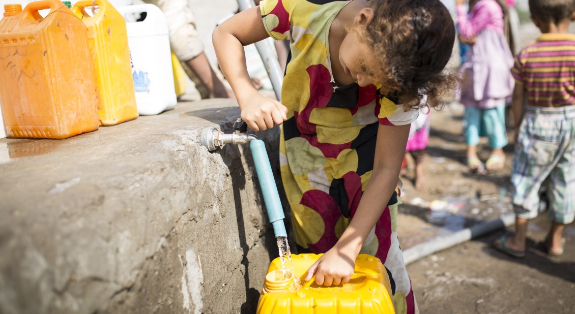 A girl gets water from a tap in Yemen.