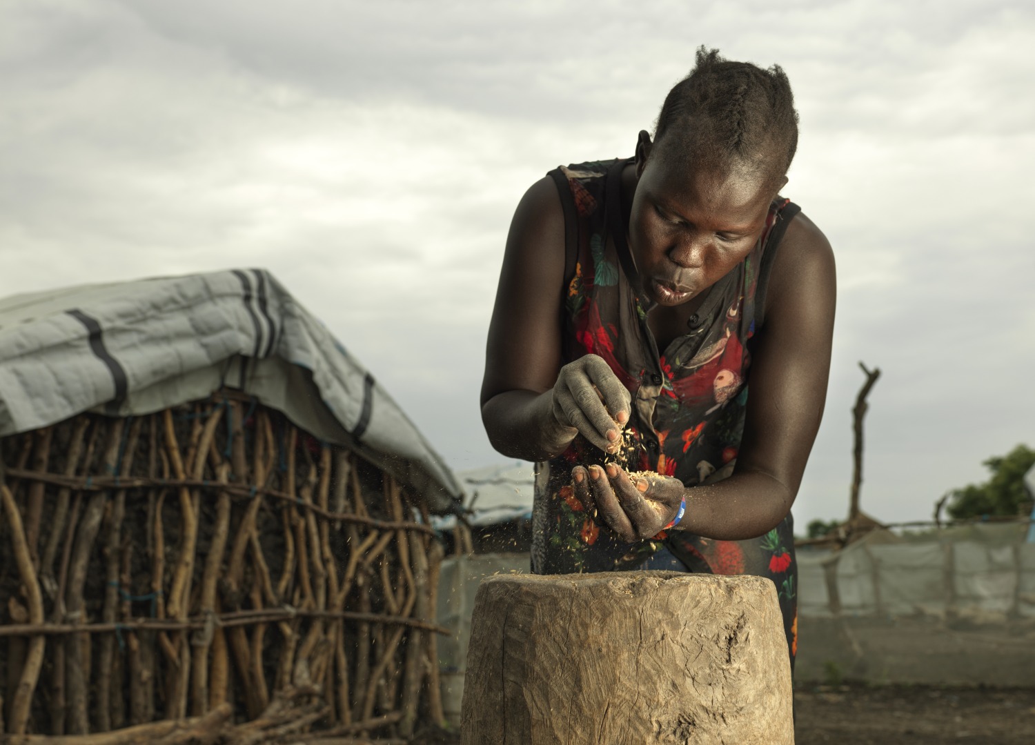Nyakieth Kulang, 22, prepares the rice by sifting out the unwanted husk.