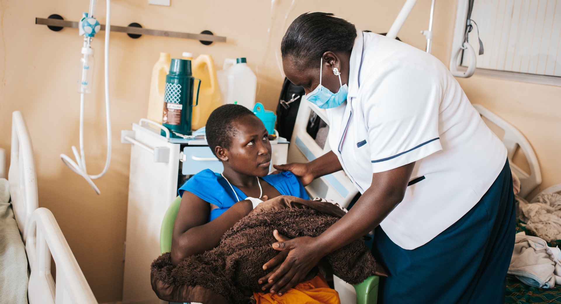 A nurse helps a young mother position her baby for breastfeeding at Kapenguria Hospital.
